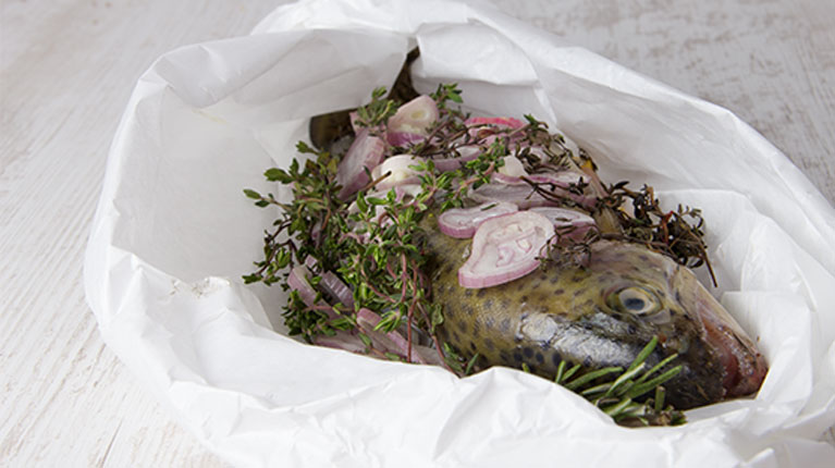 Regenbogenforelle in Pergamentpapier gebacken